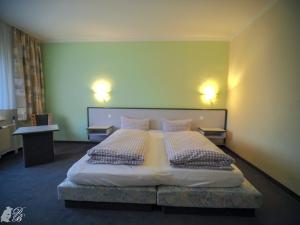 HarztorHotel und Restaurant Harzparadies的一间卧室配有一张大床和两个枕头