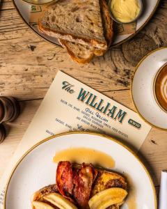 伦敦The William的桌上的盘子,带书和面包