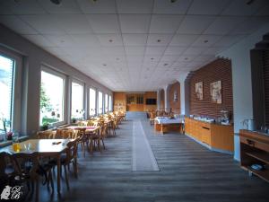HarztorHotel und Restaurant Harzparadies的用餐室设有桌椅和窗户。