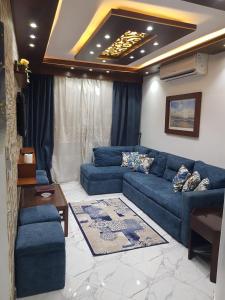 塞得港Porto said بورتوسعيد شاليه غرفه وصاله的客厅配有蓝色的沙发和桌子