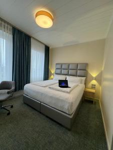 多特蒙德NP Hotel Königshof的一间卧室配有一张带笔记本电脑的床