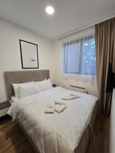兹拉蒂博尔Zlatiborske terase Spa&Wellness的卧室配有带毛巾的大型白色床