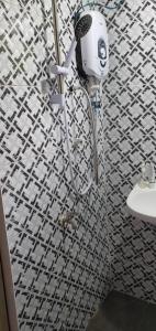 Hutan MelintangLa Familia Homestay Bagan Datuk的浴室铺有黑白瓷砖,设有淋浴。