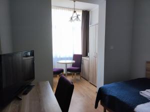 米兹多洛杰Polonia的客房设有床、电视和桌子。