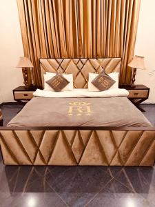 伊斯兰堡Reina Boutique Hotel - G9的一间卧室配有一张大床和木制床头板