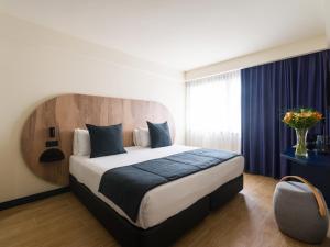 大加那利岛拉斯帕尔马斯Sercotel Playa Canteras的一间卧室,卧室内配有一张大床