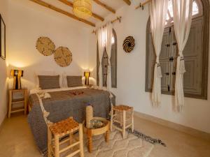 马拉喀什Riad Nelia De Marrakech Hotel Boutique & Spa的卧室配有一张床和一张桌子及椅子