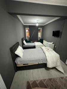 YıldırımREYNA OTEL的一间卧室配有两张床,并在房间内配有电视