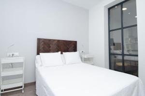马德里We Madrid Casa Duque的白色卧室配有一张带白色床单的大床