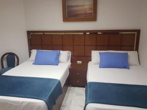 塞得港Porto said بورتوسعيد شاليه غرفه وصاله的两张带蓝色枕头的床