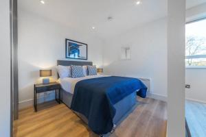 东格林斯特德Modern Studio Apartment in East Grinstead的一间卧室配有一张带蓝色毯子的床