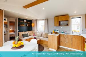 劳雷尔苏格Siblu camping Lauwersoog的厨房以及带沙发和桌子的客厅。