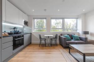 东格林斯特德Contemporary Studio Apartment in East Grinstead的厨房以及带沙发和桌子的客厅。