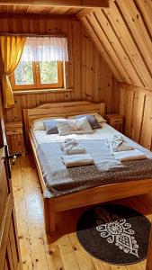 新塔尔格Domek w Górach- Bacówka u Dudka的小屋内一间卧室,配有一张大床