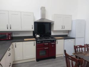 赖厄德Cwm Clyd - Carthouse的厨房配有白色橱柜和炉灶烤箱。