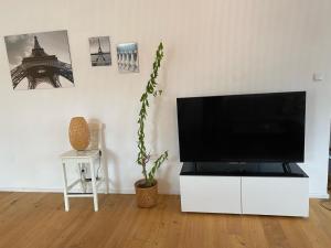 克拉根福Altbau mit Flair的客厅配有白色橱柜上的平面电视