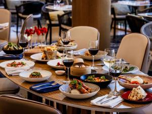 悉尼达令港诺富特悉尼酒店的餐桌,带食物盘和酒杯