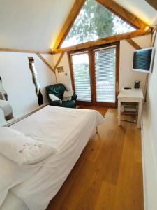 哈斯尔米尔LITTLE OAK - Kingsize Double Oak Studio - Sleeps 2 - Quirky - Rural的一间卧室设有一张大床和一个窗户。