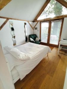 哈斯尔米尔LITTLE OAK - Kingsize Double Oak Studio - Sleeps 2 - Quirky - Rural的一间设有白色床的卧室,位于带窗户的房间内