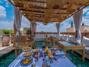 马拉喀什Riad Nelia De Marrakech Hotel Boutique & Spa的户外用餐区配有餐桌和食物