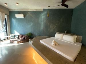 爱妮岛Happiness Kulambo Villa El Nido的一间卧室设有一张大床和绿色的墙壁