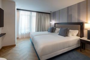 马德里Hyatt Regency Hesperia Madrid的酒店客房设有两张床和窗户。