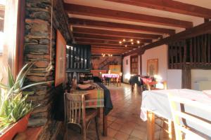 BecerrilHotel Rural La Encantada en Riaza的一间带桌椅和石墙的餐厅