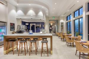 查尔斯顿Hilton Club Liberty Place Charleston的餐厅设有酒吧和桌椅