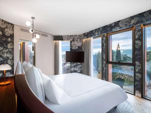 第比利斯Swissôtel Tbilisi的卧室设有一张白色大床和大窗户