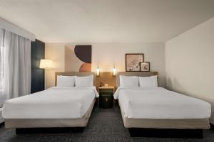 韦恩堡Spark By Hilton Fort Wayne的配有白色床单的酒店客房内的两张床