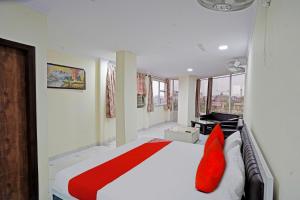 加济阿巴德OYO Flagship Hotel Jojo In的卧室配有带红色枕头的大型白色床