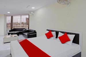 加济阿巴德OYO Flagship Hotel Jojo In的卧室配有红色和白色的床和钢琴