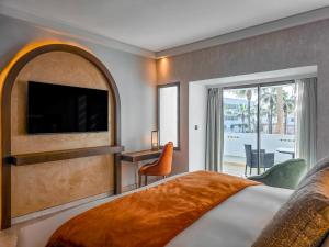 阿加迪尔Sofitel Agadir Royal Bay Resort的酒店客房,配有床和电视