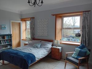 克里敦BARHOLM CROFT Holiday Cottage的卧室配有床、椅子和窗户。