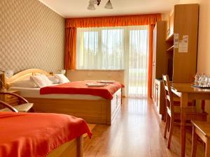 科马罗姆哈特维泽公寓酒店的一间卧室设有两张床、一张桌子和一个窗口