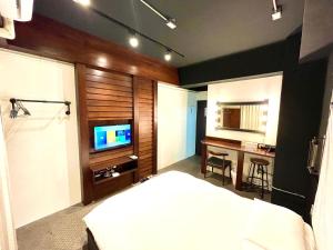 台中市逢甲沐蓁的一间卧室配有一张床、一张书桌和一台电视