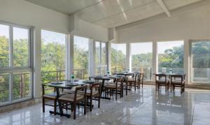 班加罗尔Treebo Trend Global Stay Jayanagar的大型客房设有桌椅和窗户。