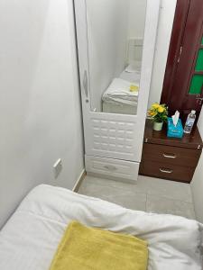 阿布扎比Cornich AD - Pearl Room的一间带镜子的卧室和一张黄色毯子的床