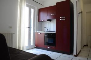 马西亚娜马里纳勒斯皮亚格公寓的厨房配有红色橱柜、水槽和炉灶。