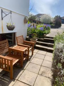 Saint ErthFerney Croft的两把木凳坐在开满鲜花的庭院里