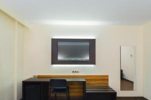 埃尔切埃尔切港酒店的客房设有一张桌子,墙上配有电视。