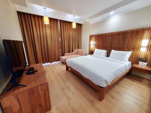 列城Hotel Amanthi Ladakh的卧室配有一张白色大床和一把椅子