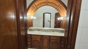 萨尔塔Valhalla Hostel & Suites的一间带两个盥洗盆和大镜子的浴室