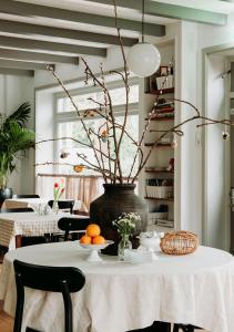 卑尔根卑尔根1928住宿加早餐旅馆的一张桌子,上面有花瓶,上面有枝子和橙子