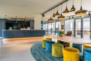 波苏埃洛-德阿拉尔孔Student Experience Madrid Pozuelo - Luxury Hostel的餐厅设有木桌和黄色凳子