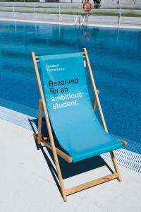波苏埃洛-德阿拉尔孔Student Experience Madrid Pozuelo - Luxury Hostel的游泳池旁椅子上的标志