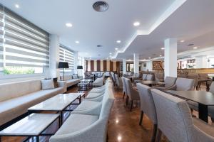 卡拉布兰卡Sagitario Playa的一间带沙发和桌椅的餐厅