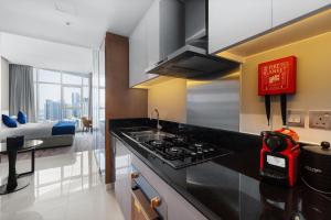 迪拜New Aparthotel Prive的一间带炉灶的厨房 客厅旁的顶级烤箱