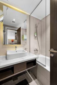 迪拜New Aparthotel Prive的一间带水槽、浴缸和镜子的浴室