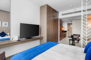 迪拜New Aparthotel Prive的一间卧室配有一张床和一台平面电视